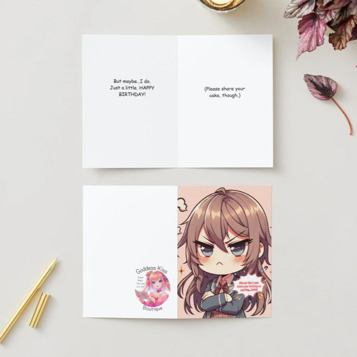 A chibi character with crossed arms, a blush, and a pout, embodying tsundere energy on an Anime Humor Card. The front text reads: “It’s not like I care about your birthday or anything… BAKA!