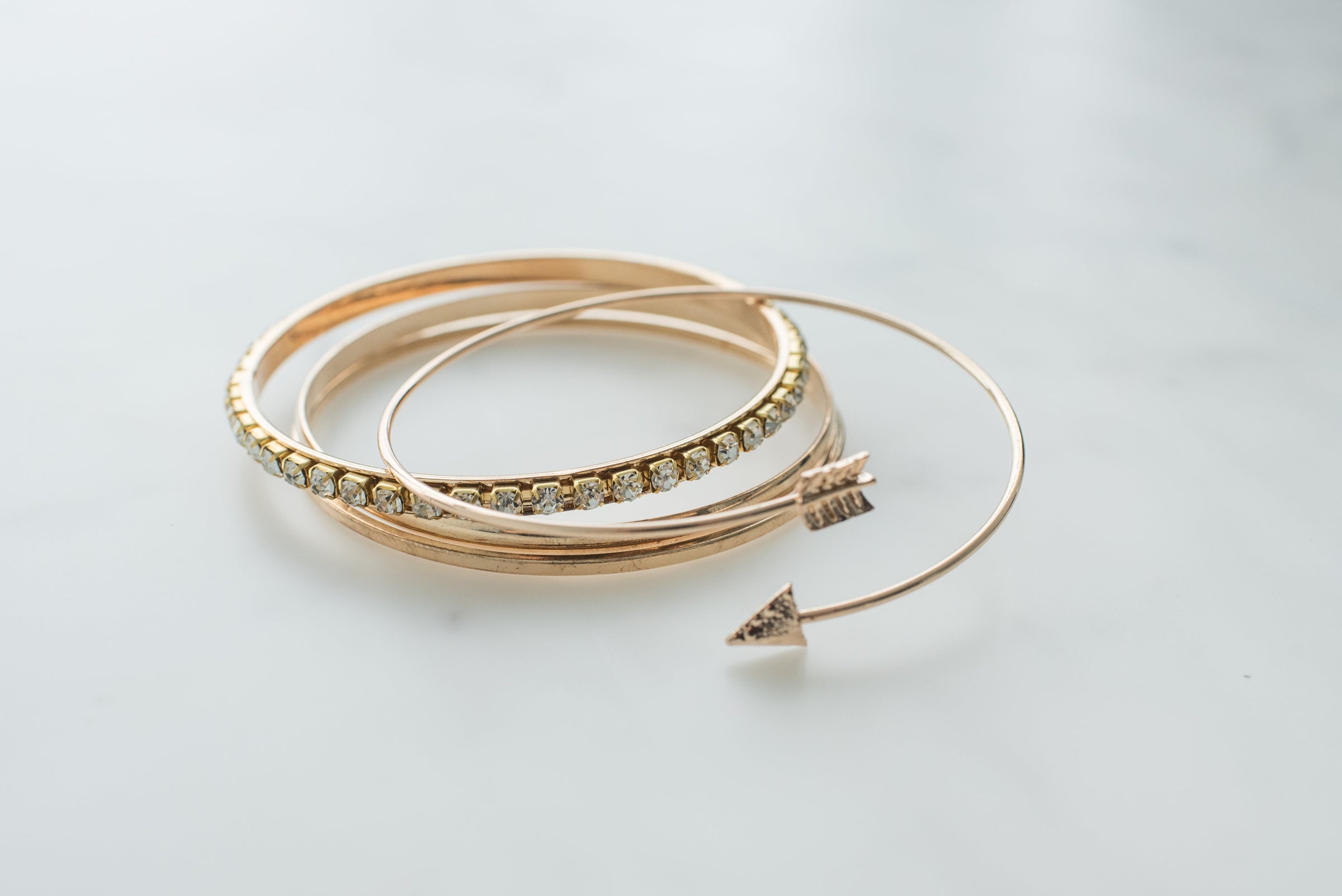 a stack of gold bangles with a diamond on each bangle