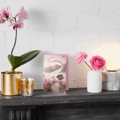 Anime-style illustration of a drifting sakura petal caught in a breeze, spiraling toward a peaceful shrine, symbolizing renewal, healing, and gentle encouragement.