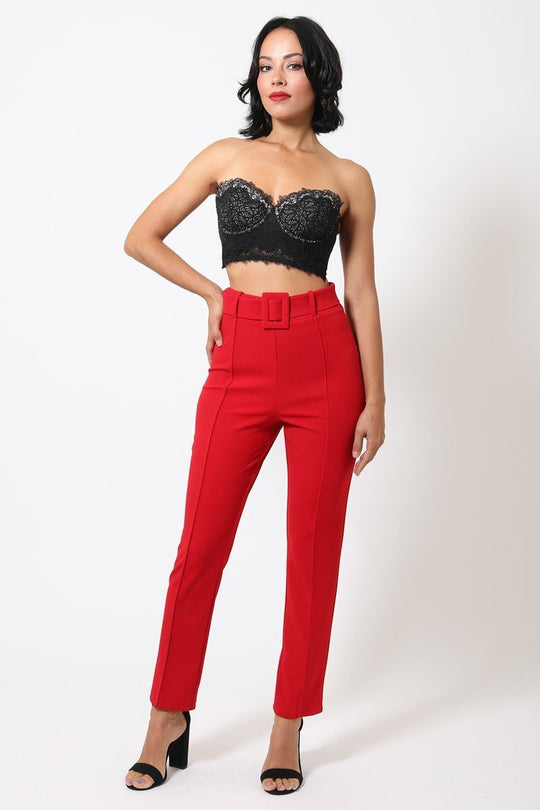 a woman in a black top and red pants