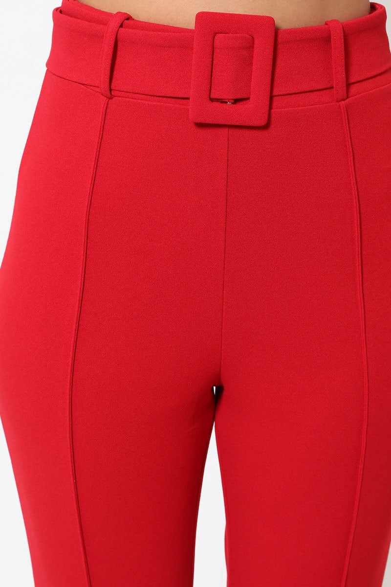 a woman in red pants with a belt