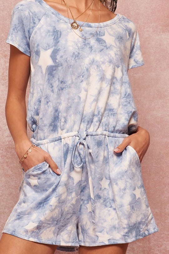 a woman wearing a blue and white tie dye romper