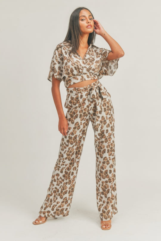 a person in a leopard print top and wide legged pants