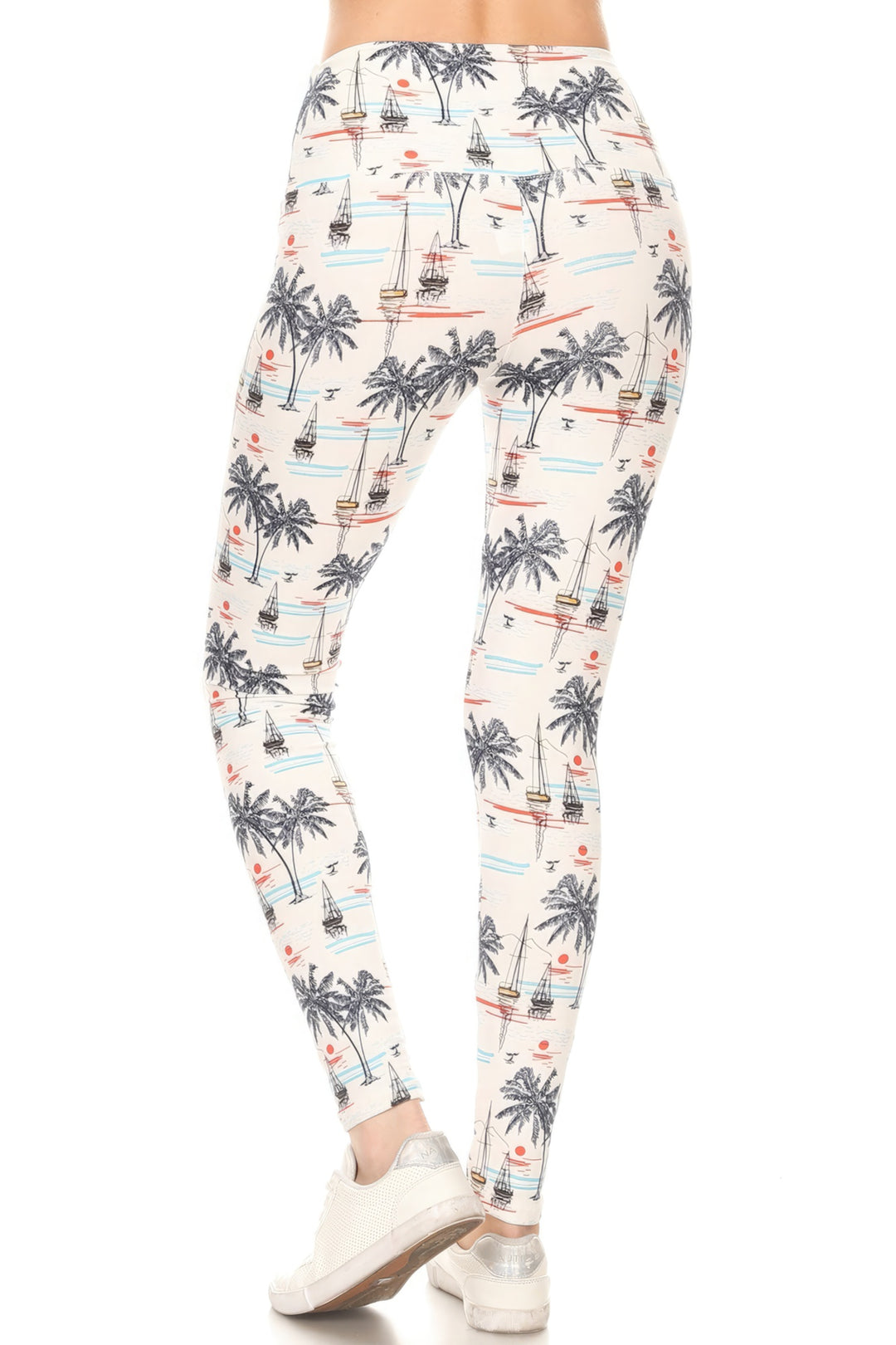 a woman in a white top and palm trees leggings