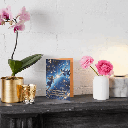 "An anime-style anniversary card featuring star-crossed lovers reaching for each other across a glowing night sky. Floating feathers and twinkling stars enhance the dreamy, celestial theme. The heartfelt message reads: 'No matter how many stars separate us, my heart will always find you.